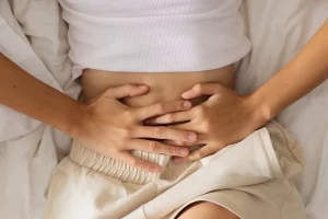 femme se touchant le bas ventre de douleur